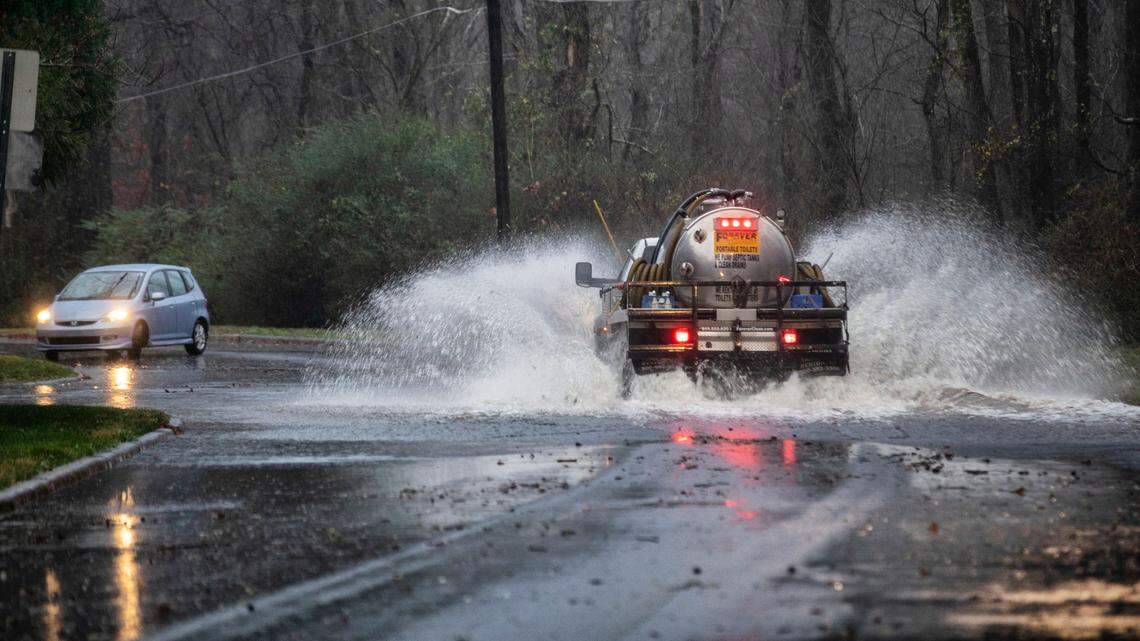 A driver turns around to avoid a flooded area as a truck drives through high water on Cleland Drive in Chapel Hill, N.C. on Monday morning, Jan. 3, 2022.