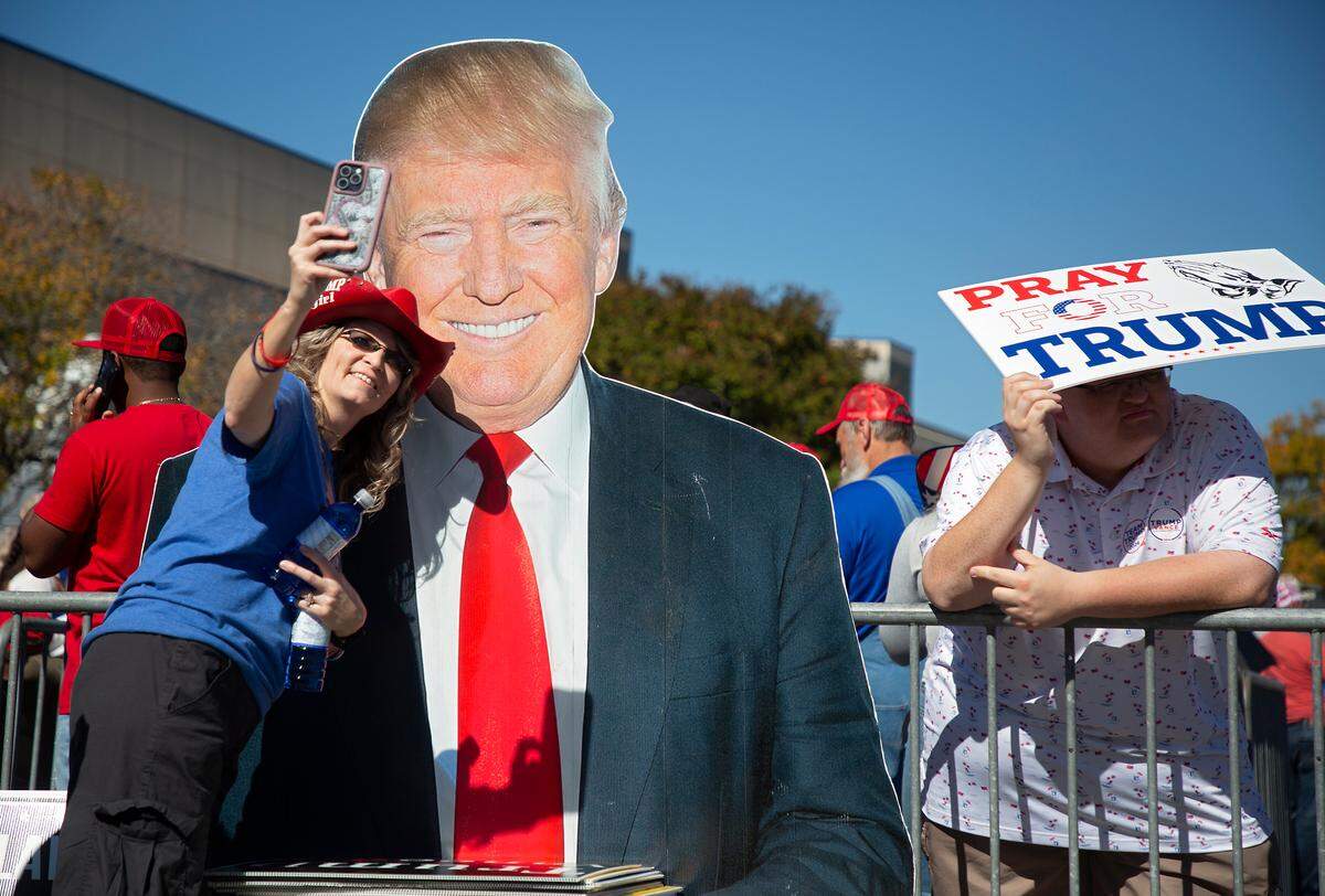 People gather next to a cut-out of former President Donald Trump prior to a rally at the Greensboro Coliseum Complex on Tuesday, Oct. 22, 2024, in Greensboro, N.C.