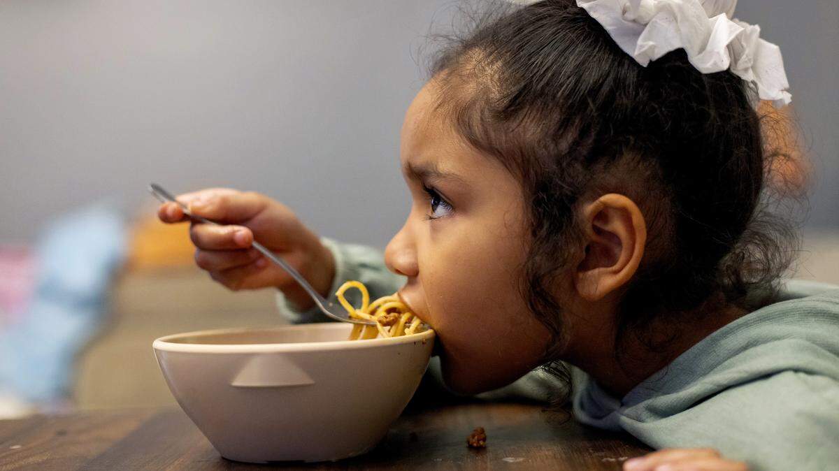 Five-year-old Atzi Gonzalez dines on a bowl of spaghetti as she watches her favorite animated feature in her home on Wednesday, October 29, 2025 in Garner, N.C. Her family receives a vital food benefit from the WIC program that could be in jeopardy due to the federal government shutdown.