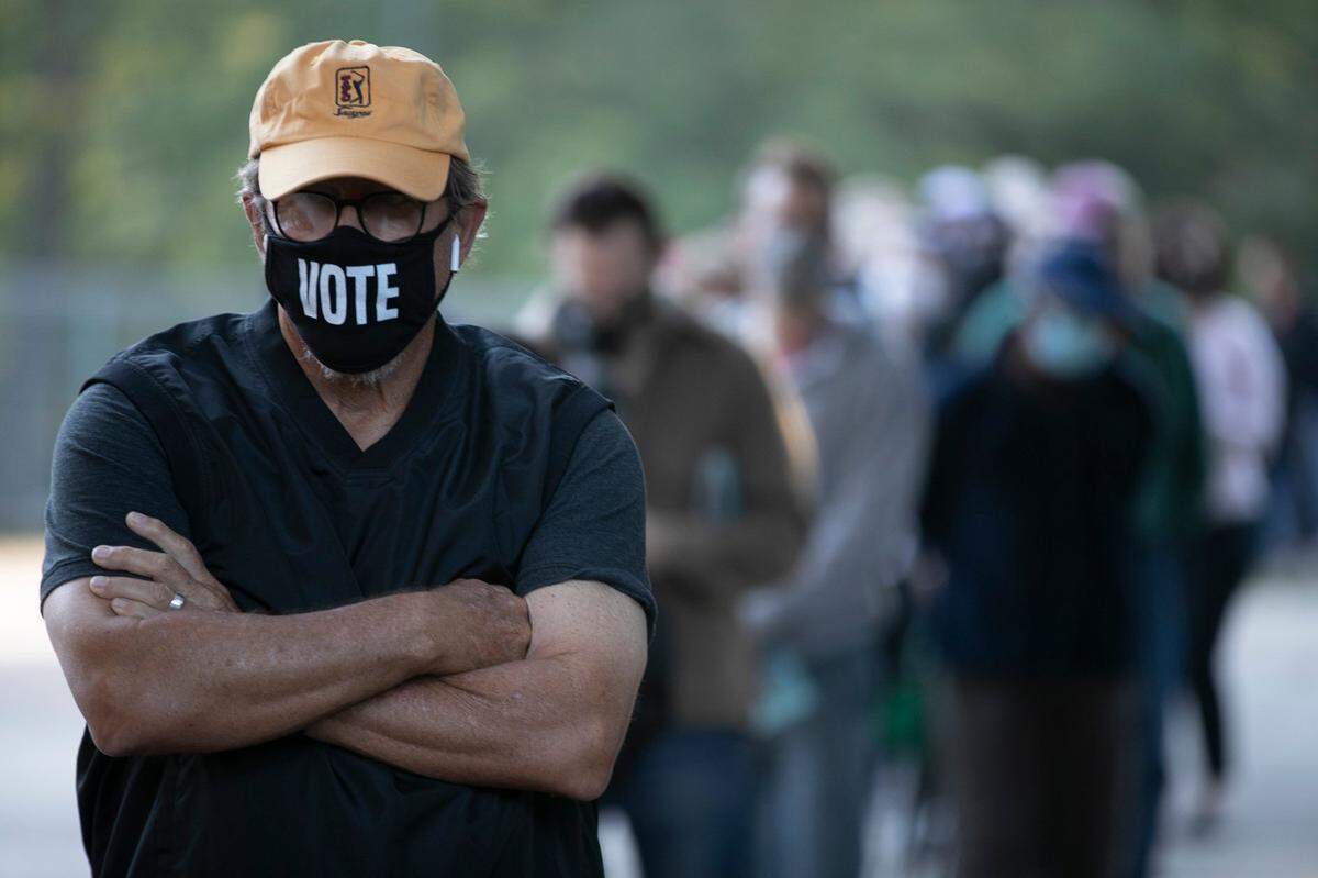 Walter Teague waits in line to vote at the Roberts Park early voting site on Thursday morning, October 15, 2020 in Raleigh, N.C. Teague was among the more than 300 people who were in line when the poll opened at 8 a.m..