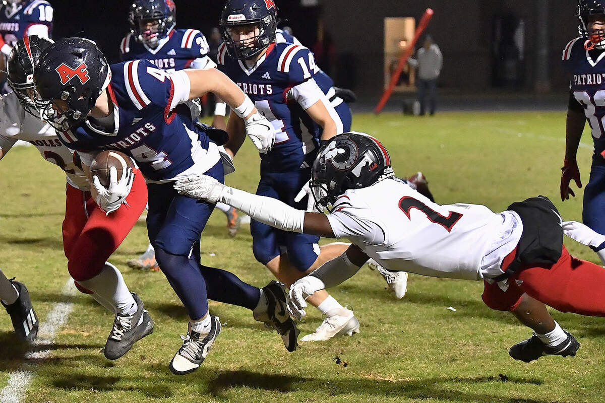 Apex Friendship wide receiver Adam Schreiber (4) runs for yardage against Rolesville defensive back Christian Agina-Obu (21) during the first half. The Apex Friendship Patriots and the Rolesville Rams met in  the second round of the  NCHSAA 8A Playoff game in Apex, N.C. on November 14, 2025. Rolesville wins 14-7 in overtime.