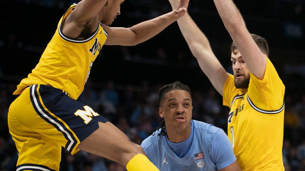Michigan’s Kobe Bufkin (2) and Hunter Dickinson (1) trap North Carolina’s Armando Bacot (5) in the first half on Wednesday, December 21, 2022 at the Spectrum Center in Charlotte, N.C. Bacot lead all scores with 26 points.