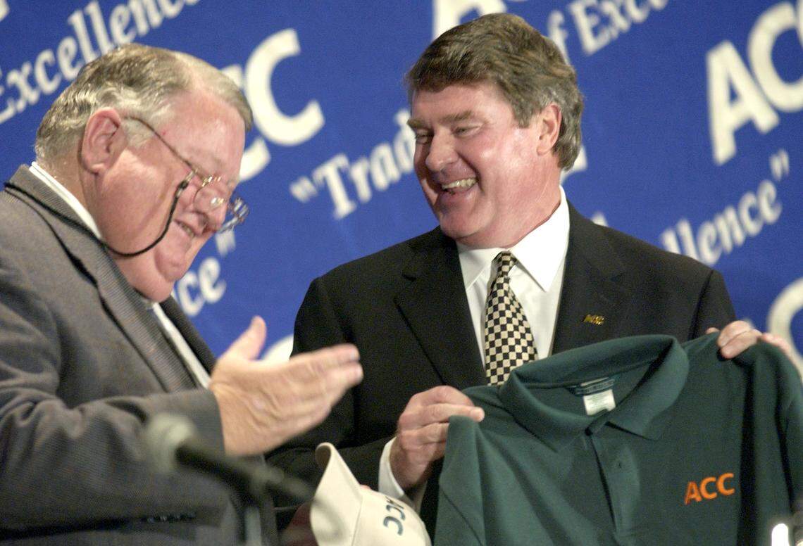 University of Miami Director of Athletics Paul Dee, left, jokes around with ACC Commissioner John Swofford while accepting a Hurricane colored ACC shirt during a press conference at the Grandover Resort & Conference Center in Greensboro in 2003. The ACC officially announced the addition of Virginia Tech and the University of Miami to the conference.