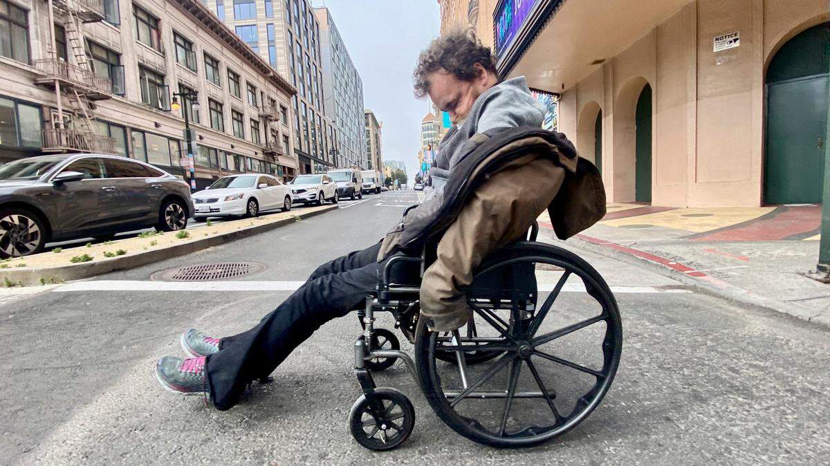 A man in a wheelchair struggles to make his way down Golden Gate Ave. near the heart of San Francisco’s Tenderloin district, which is known for its high rate of crime and its large population of the homeless.