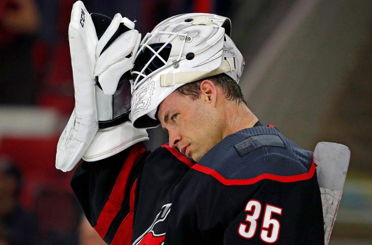 Carolina Hurricanes goaltender Curtis McElhinney (35) takes a break against the Edmonton Oilers during the third period of an NHL hockey game, Friday, Feb. 15, 2019, in Raleigh, N.C. (AP Photo/Karl B DeBlaker)
