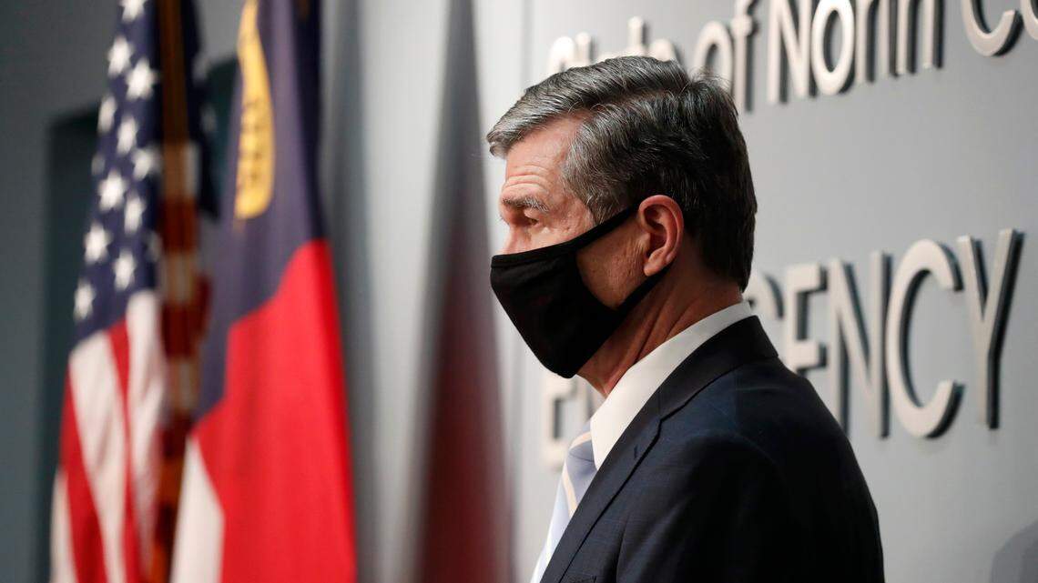 Gov. Roy Cooper listens as Director of Emergency Management Mike Sprayberry speaks during a briefing at the Emergency Operations Center in Raleigh, N.C., Tuesday, Dec. 15, 2020.