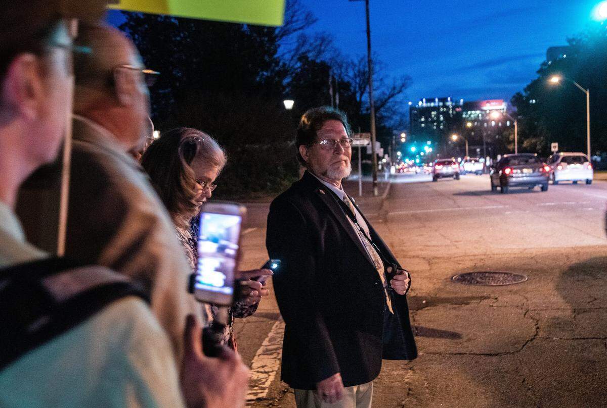 State Rep. Larry Pittman is heckled by a protester while being escorted across the street following a reception at the United Daughters of the Confederacy house in downtown Raleigh on Tuesday night, Feb. 5, 2019. The reception sponsored by the North Carolina Division Sons of Confederate Veterans and the protest came during the ongoing debate over Confederate monuments on public property.
