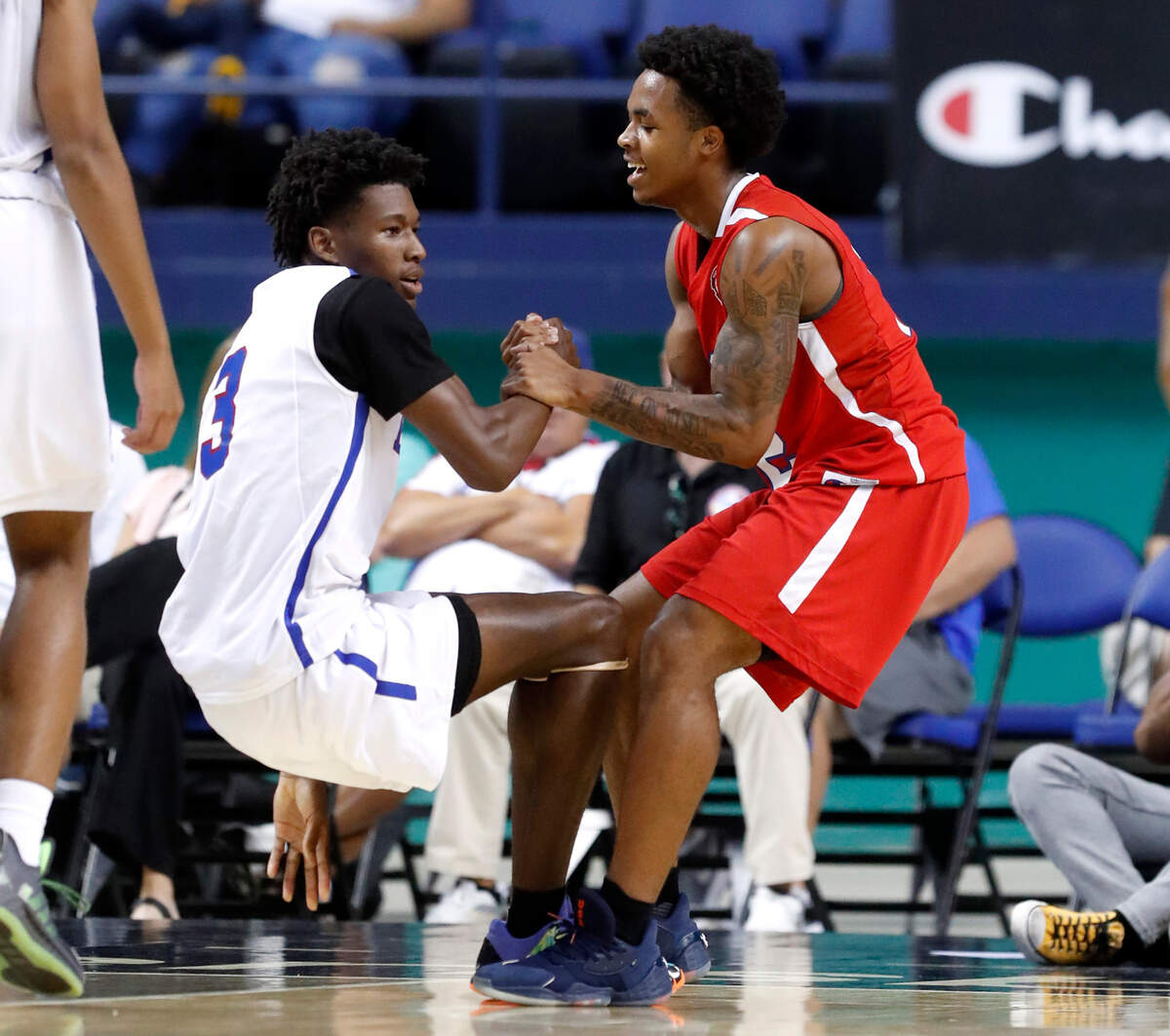 West’s Breon Pass (12) helps up East’s Terquavion Smith (3) after Pass fouled Smith during the second half of the North Carolina High School Athletic Association men’s basketball All-Star game at Greensboro Coliseum in Greensboro, N.C., Monday, July 19, 2021.