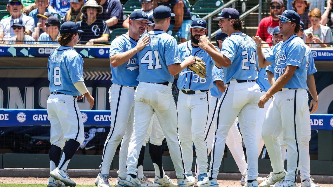 Carolina’s pitcher Will Sandy, third from left, is greeted by teammates from the dugout after a strikeout during the ACC baseball semifinals against Notre Dame at Truist Field on Saturday, May 28, 2022 in Charlotte, NC.