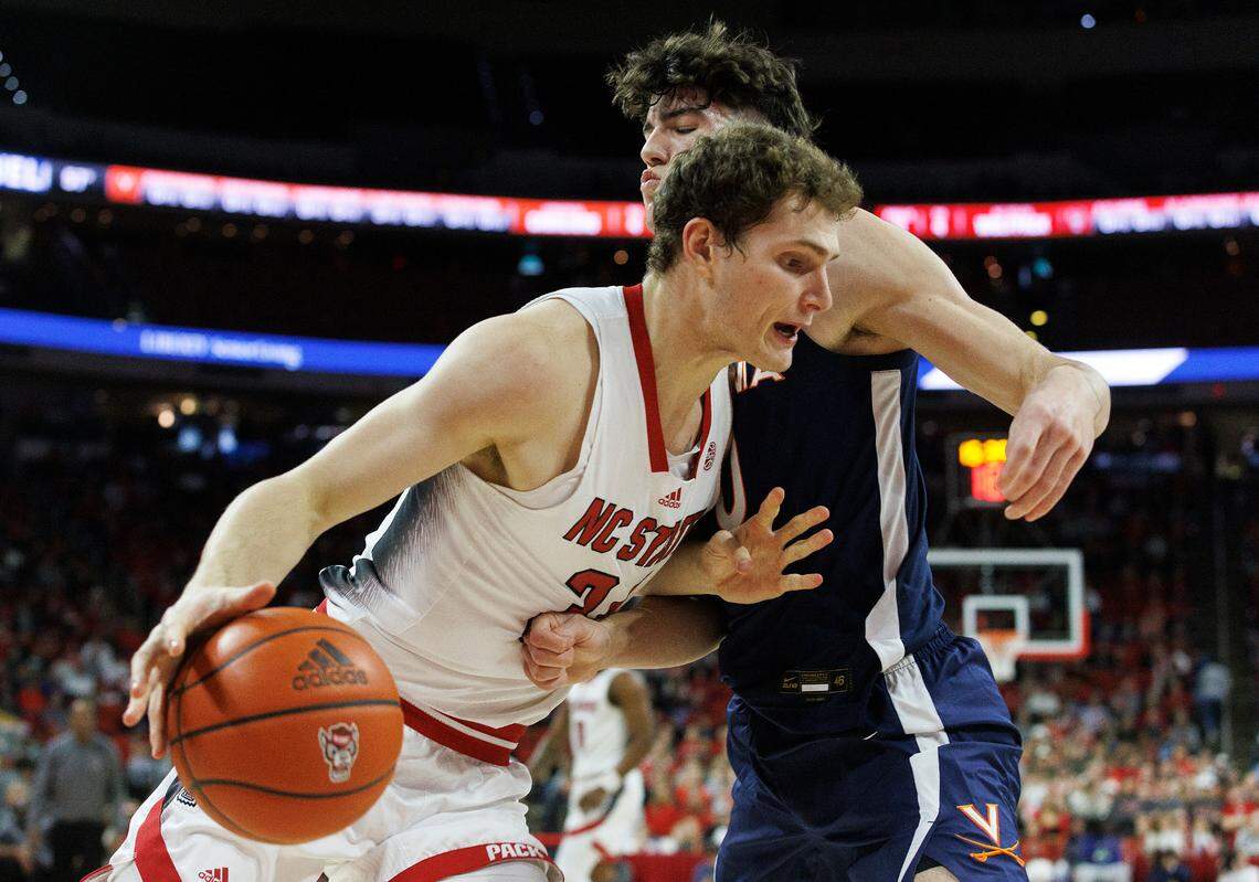 N.C. State’s Ben Middlebrooks drives by Virginia’s Blake Buchanan during the first half of the Wolfpack’s 76-60 win on Saturday, Jan. 6, 2024, at PNC Arena in Raleigh, N.C.
