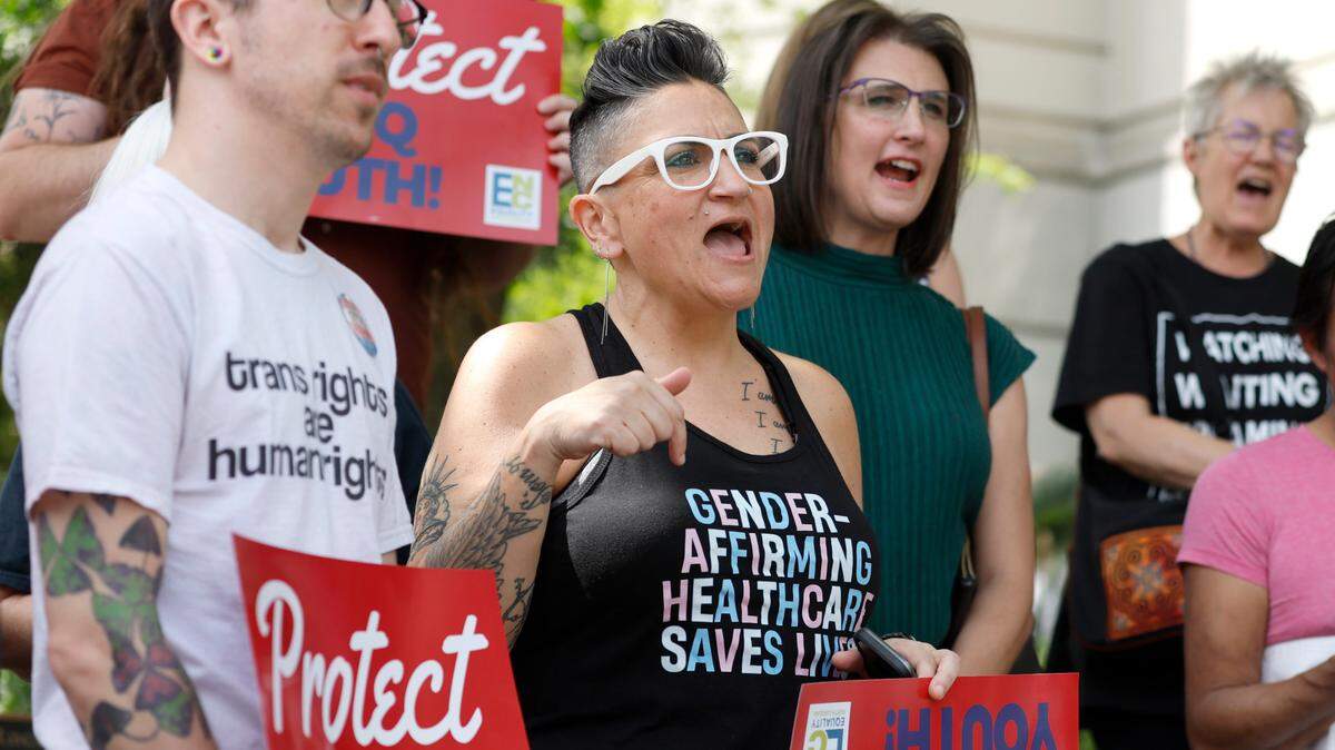 Gwenn Mangine of Cary, center, and others participate in a rally opposing HB 574 and SB 631 outside the NC Legislative building Thursday, April 20, 2023. House Bill 574 bans transgender athlete participation in women’s sports in middle, high school and college.