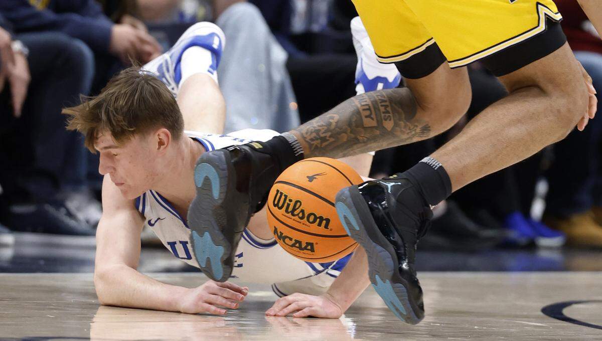 Duke’s Nikolas Khamenia (14) dives after the loose ball during the first half of Duke’s game against Michigan in the Capital Showcase at Capital One Arena in Washington, D.C., Saturday, Feb. 21, 2026.