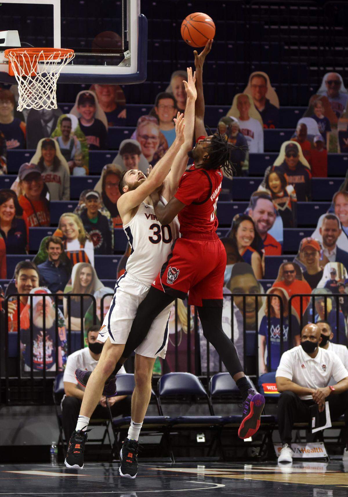 North Carolina State forward DJ Funderburk (0) is fouled by Virginia forward Jay Huff (30) during the game Wednesday in Charlottesville, Va. North Carolina State defeated Virginia 68-61.