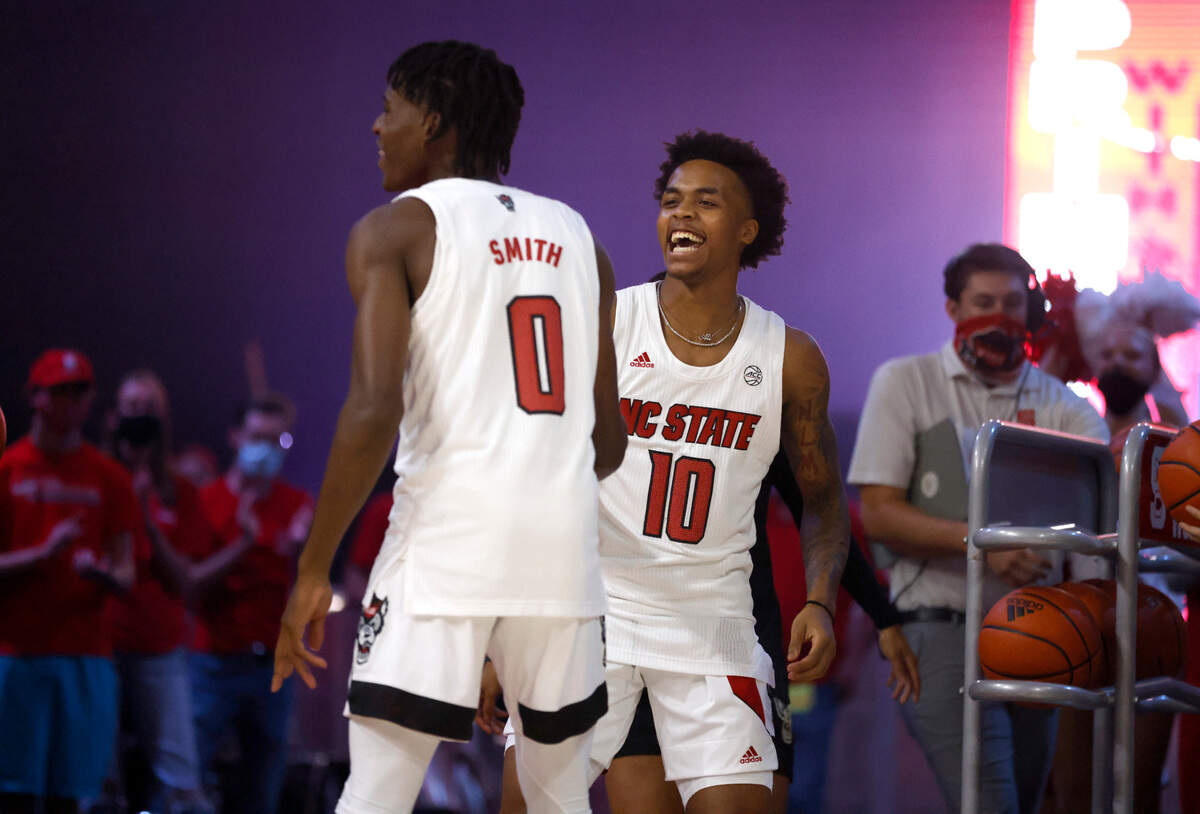 N.C. State’s Breon Pass (10) and Terquavion Smith (0) celebrate after hitting a half-court shot during Primetime with the Pack at Reynolds Coliseum in Raleigh, N.C., Thursday, October 14, 2021.