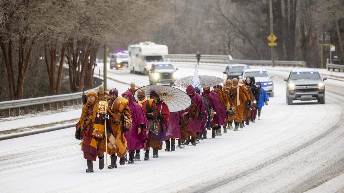 A procession of Buddhist monks walks along snow-covered Raleigh Boulevard in Raleigh on Sunday morning, Jan. 25, 2026. The monks are making a 2,300-mile pilgrimage from Texas to Washington, D.C., as part of the Walk for Peace, an effort to promote peace, compassion and national unity.