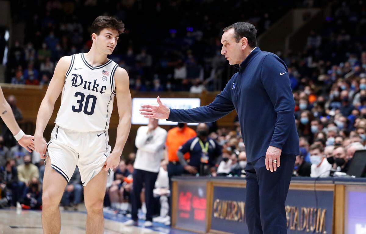 Duke head coach Mike Krzyzewski talks with Michael Savarino (30), his grandson, during the second half of Duke’s 79-59 victory over Syracuse at Cameron Indoor Stadium in Durham, N.C., Saturday, Jan. 22, 2022.