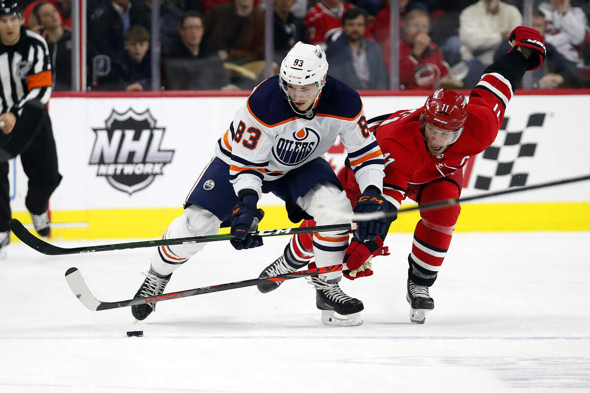 Edmonton Oilers’ Matt Benning (83), of Sweden, and Carolina Hurricanes’ Jordan Staal (11) compete for the puck during the first period of an NHL hockey game in Raleigh, N.C., Sunday, Feb. 16, 2020. (AP Photo/Karl B DeBlaker)