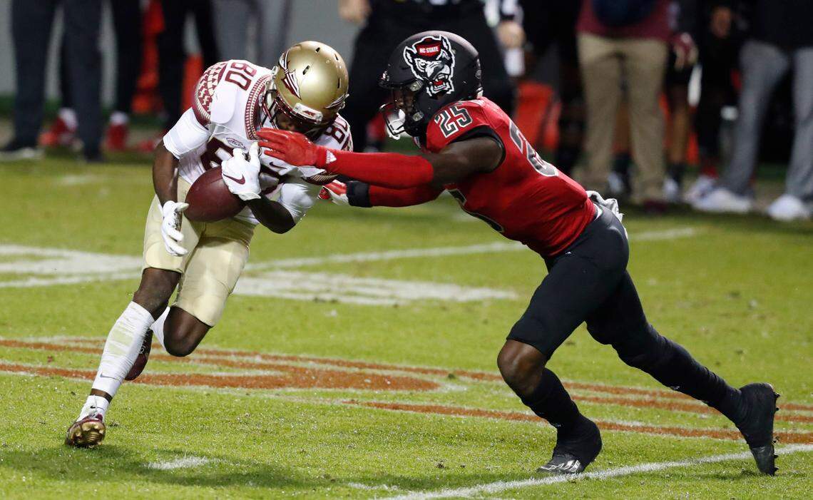 N.C. State cornerback Shyheim Battle (25) tackles Florida State wide receiver Ontaria Wilson (80) during the first half of N.C. State’s game against Florida State at Carter-Finley Stadium in Raleigh, N.C., Saturday, Nov. 14, 2020.