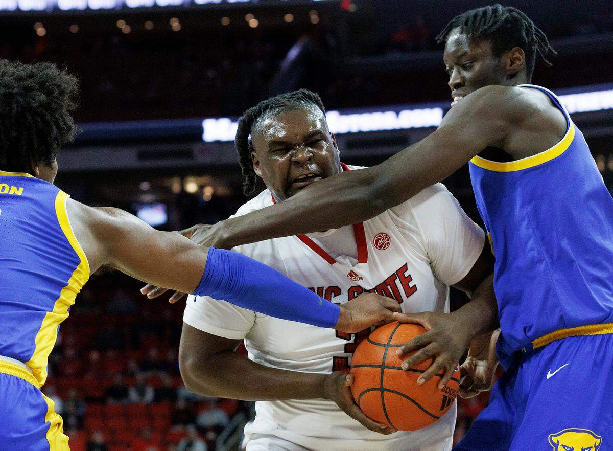 N.C. State’s DJ Burns Jr. drives to the basket past Pittsburgh’s Blake Hinson and Federiko Federiko during the first half of the Wolfpack’s game on Wednesday, Feb. 7, 2024, at PNC Arena in Raleigh, N.C.