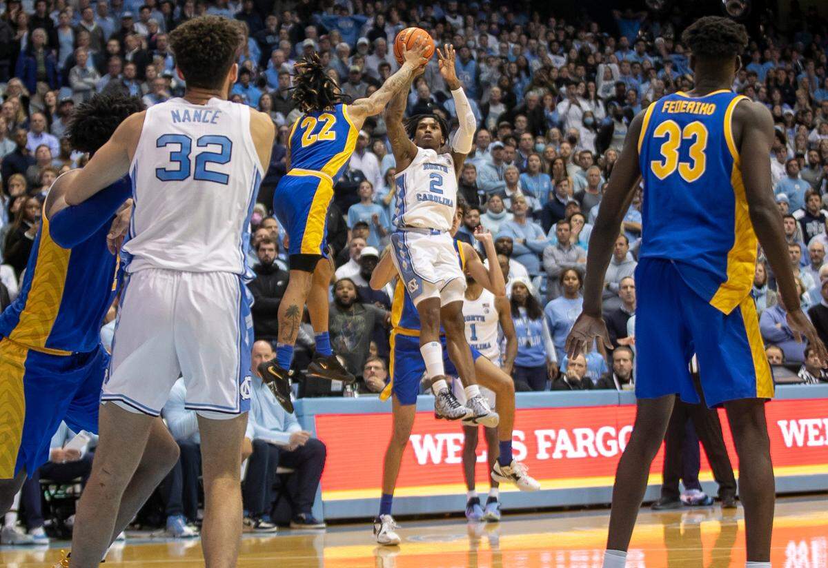 Pittsburgh’s Nike Sibande (22) defends North Carolina’s Caleb Love (2) as he tries a desperation shot with no time left, securing a 65-64 victory by Pittsburgh on Wednesday, February 1, 2023 at the Smith Center in Chapel Hill, N.C.