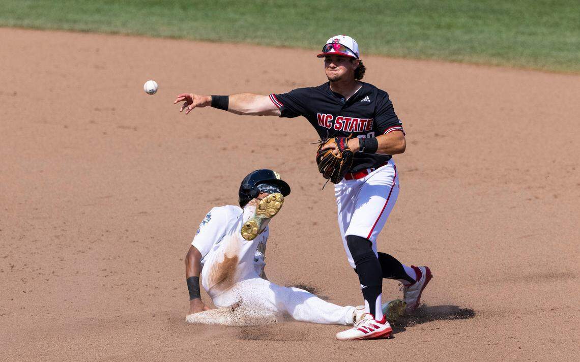 North Carolina State’s Carson Falsken, right, tags out Vanderbilt’s Javier Vaz, left, at second base and attempts to turn a double play off a single hit by CJ Rodriguez in the seventh inning during a baseball game in the College World Series, Friday, June 25, 2021, at TD Ameritrade Park in Omaha.