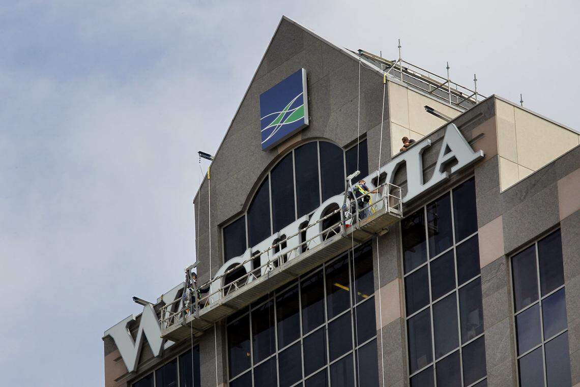 Workers take the Wachovia sign off a building in Raleigh in 2011. Wells Fargo agree to buy the Charlotte-based bank in 2008. File photo