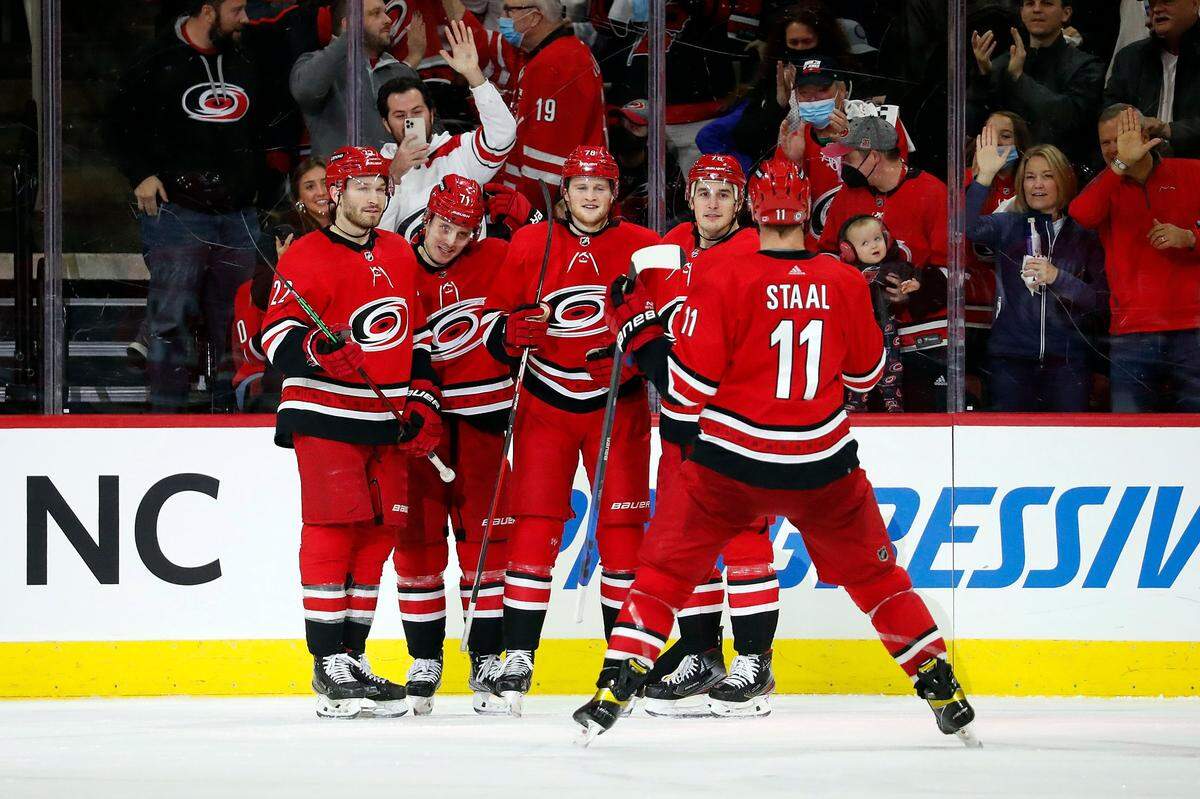 Carolina Hurricanes’ Steven Lorentz, center, celebrates his goal with teammates Brett Pesce (22), Jesper Fast (71), Brady Skjei (76) and Jordan Staal (11) during the third period of an NHL hockey game Vancouver Canucks in Raleigh, N.C., Saturday, Jan. 15, 2022. (AP Photo/Karl B DeBlaker)