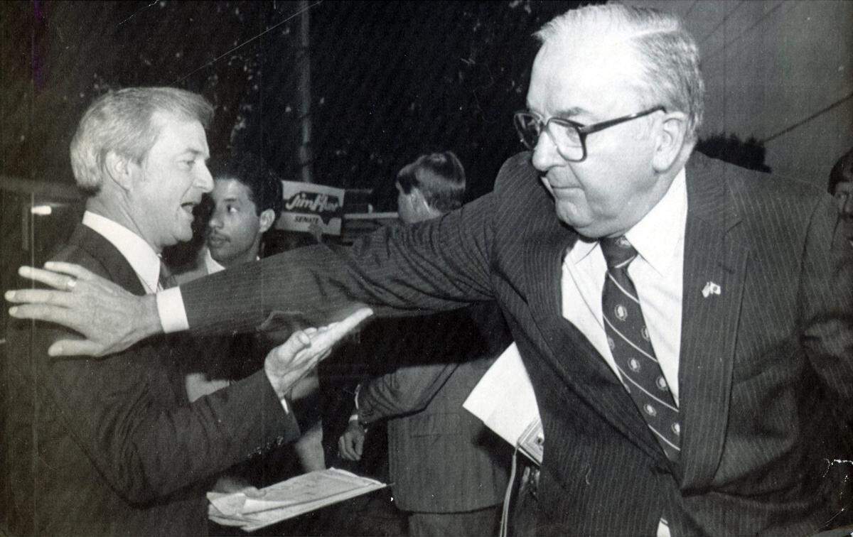 U.S. Senator Jesse Helms gives Democratic opponent Gov. Jim Hunt a pat on the shoulder following the first televised debate between the two candidates in 1984.