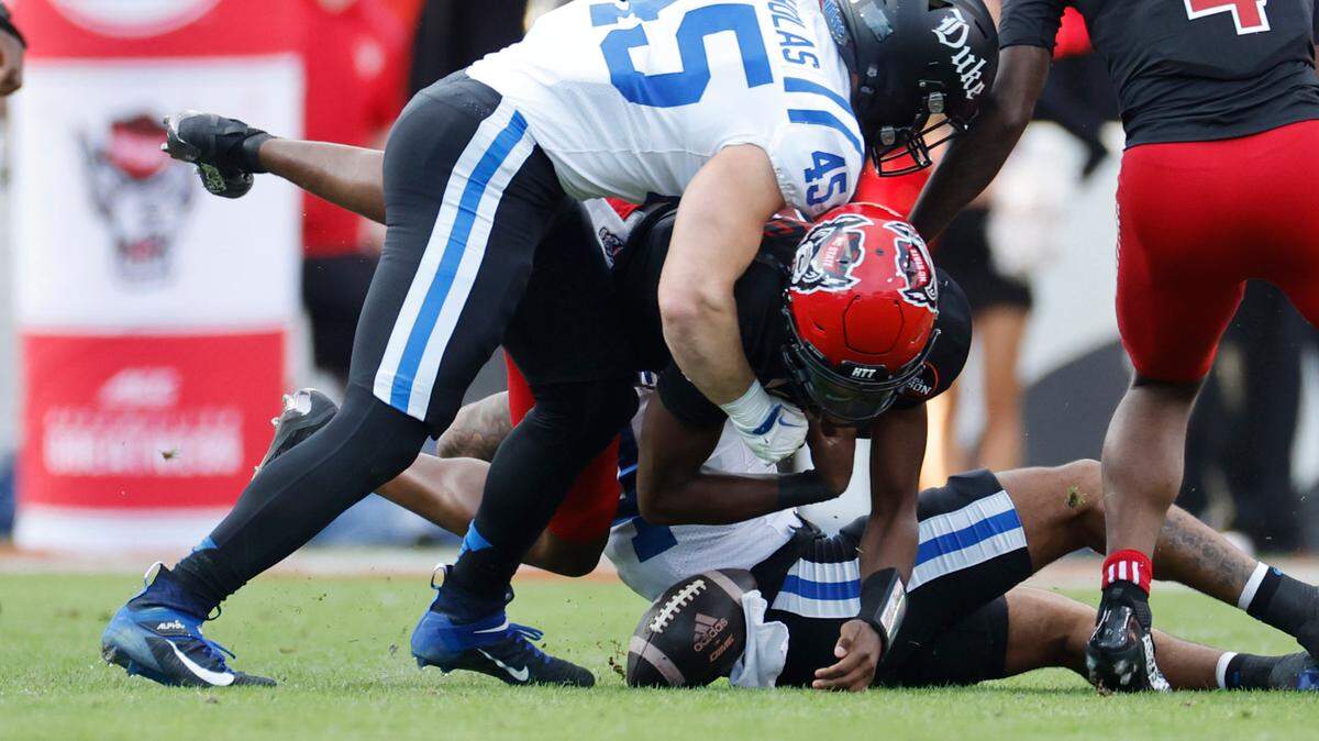 N.C. State quarterback CJ Bailey (16) fumbles the ball while being tackled by Duke linebacker Ozzie Nicholas (45) during the first half of N.C. State’s game against Duke at Carter-Finley Stadium in Raleigh, N.C., Sat. Nov. 9, 2024.