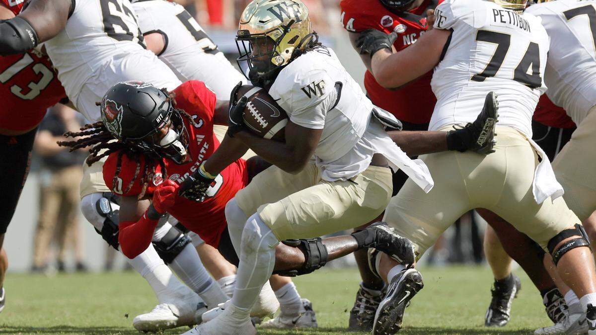 Wake Forest running back Demond Claiborne (1) sheds the attempted tackle by N.C. State linebacker Sean Brown (0) before a long run during the second half of Wake Forest’s 34-30 victory over N.C. State at Carter-Finley Stadium in Raleigh, N.C., Saturday, Oct. 5, 2024.