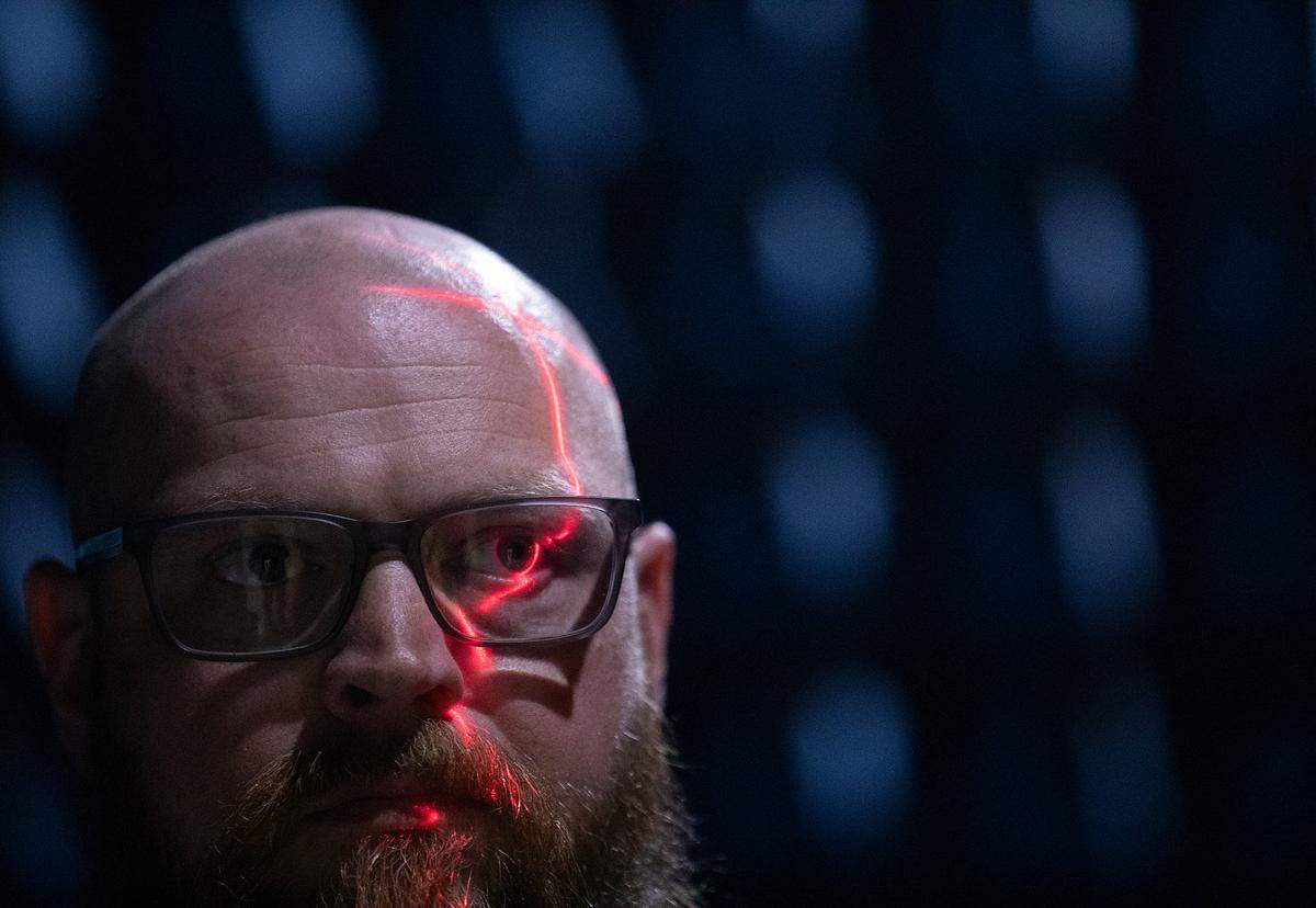 Jordan Stearns, operations manager at the Wireless Research Center of NC, is illuminated by a laser beam inside one of the facility’s anechoic chambers in Wake Forest, N.C. The chamber, which is padded with radio frequency absorber, is used to test equipment.