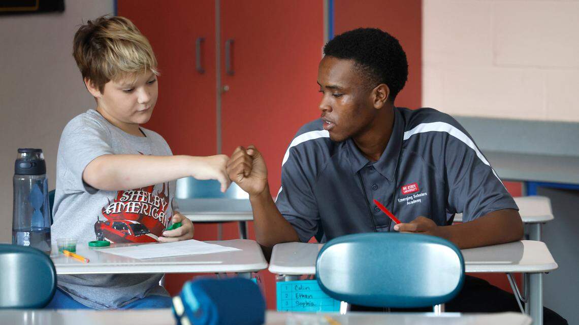 Jahzar Fields fist bumps sixth-grader Simon Metz while student teaching in Kerry Miquel’s social studies class at Dillard Drive Magnet Middle School in Raleigh, N.C., Wednesday, Sept. 6, 2023.
