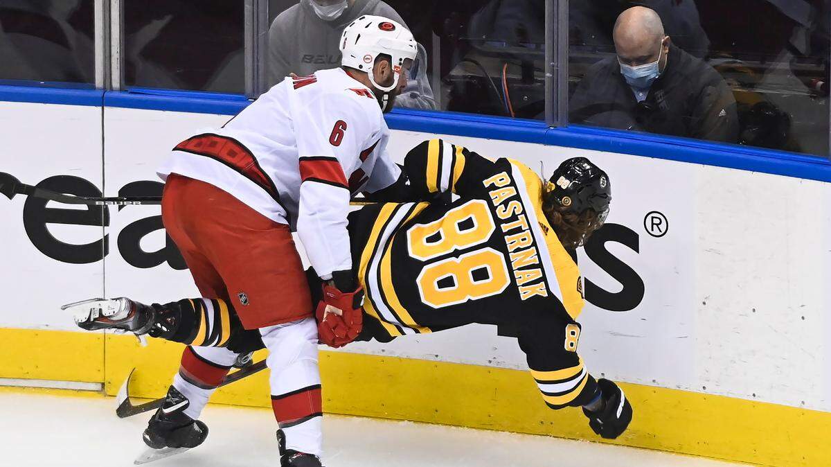 Carolina Hurricanes defenseman Joel Edmundson (6) hits Boston Bruins right wing David Pastrnak (88) during the first period of Game 1 of the first round of the NHL playoffs in Toronto, Wednesday, Aug. 12, 2020.