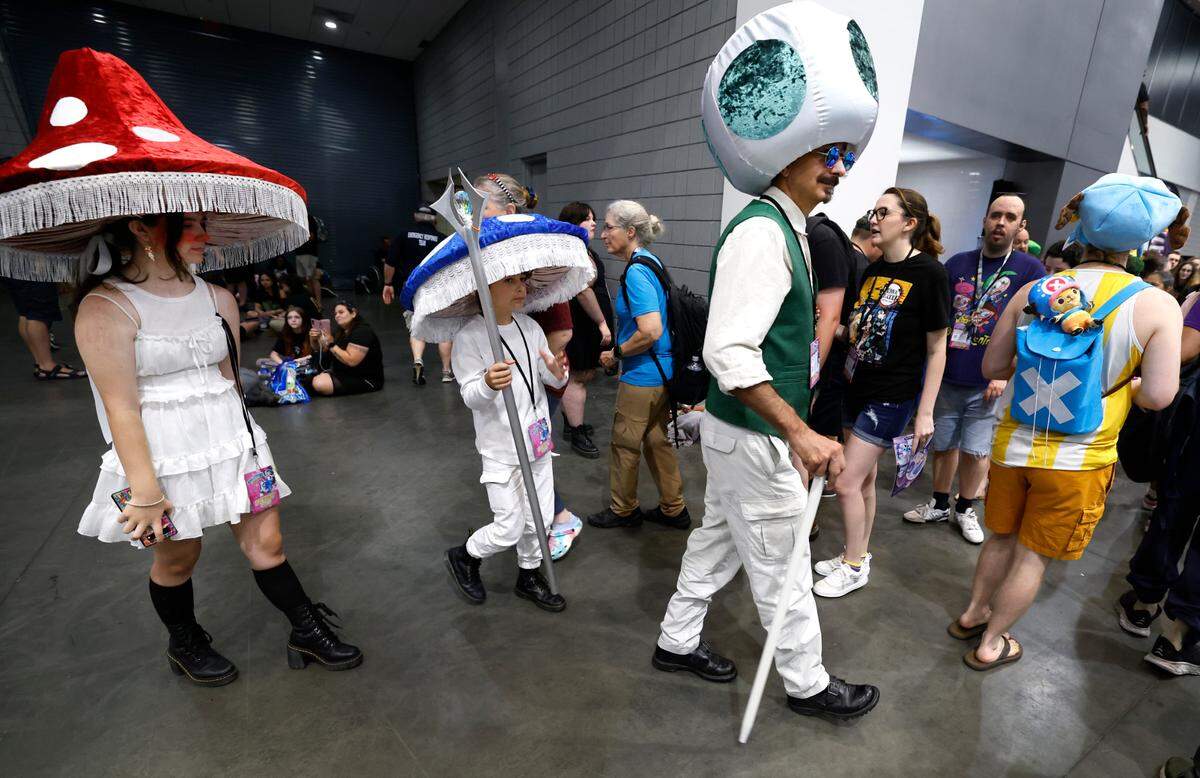 Todd Matich of Greensboro along with his son Gunner, 9, and daughter Madison, 13, walk the exhibition hall floor at the Raleigh Convention Center during GalaxyCon on Saturday, July 27, 2024. The three are characters from the Super Mario Brothers movie.