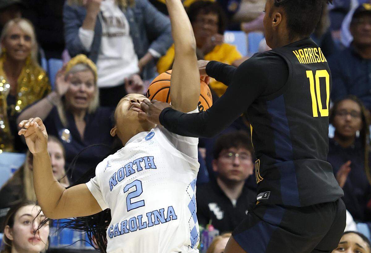 West Virginia’s Jordan Harrison (10) knocks the ball from North Carolina’s Grace Townsend (2) during the first half of UNC’s game against West Virginia in the second round of the NCAA women’s basketball tournament at Carmichael Arena in Chapel Hill, N.C., Monday, March 24, 2025.