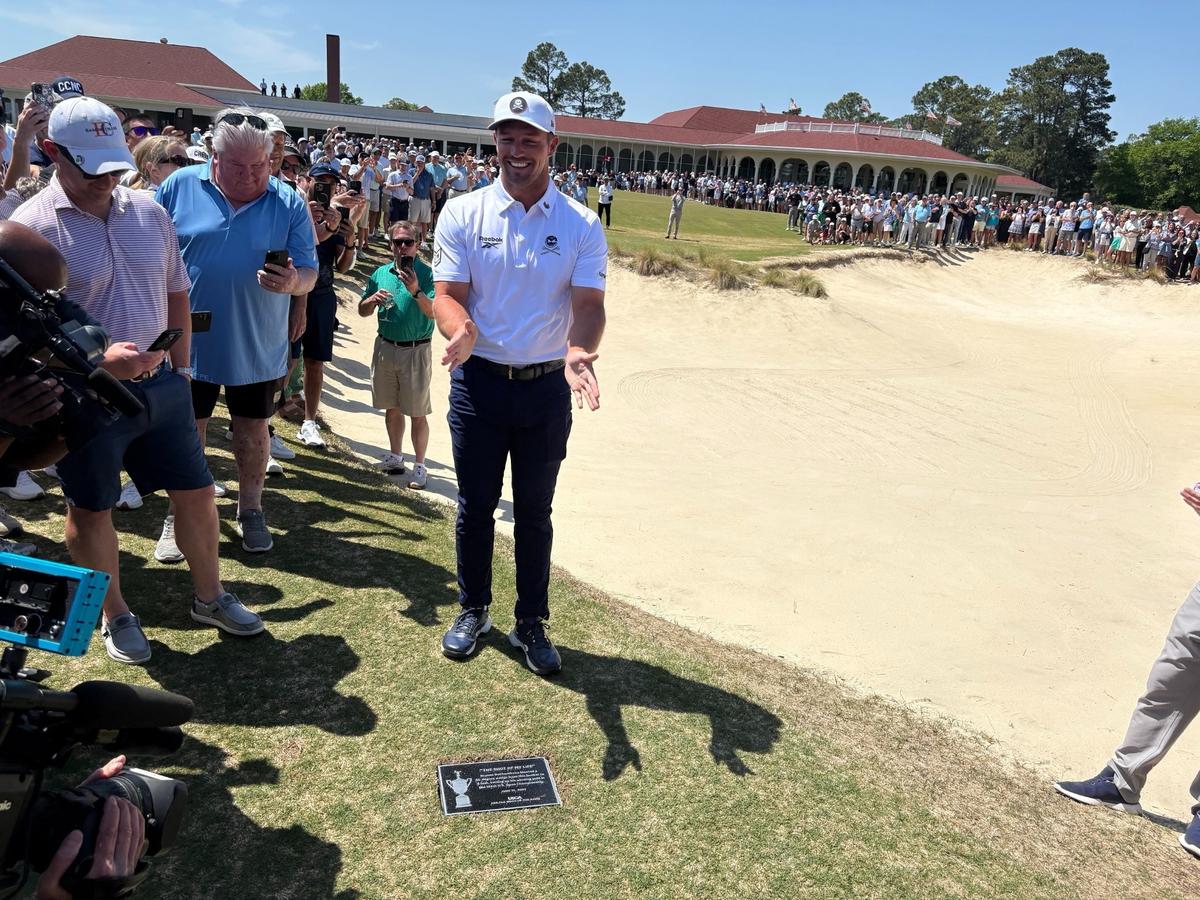 Bryson DeChambeau poses with the plaque commemorating his U.S. Open-winning bunker shot on the 18th hole of Pinehurst’s No. 2 course last June. DeChambeau was back at Pinehurst for the installation of the plaque Monday.