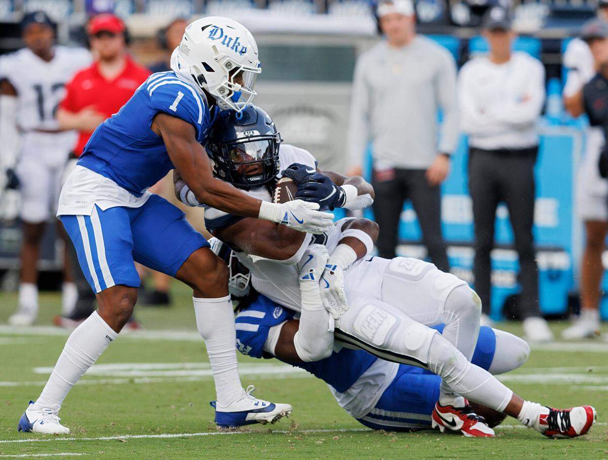 Duke’s Terry Moore and Tre Freeman tackle Connecticut’s Cam Edwards during the first half of the Blue Devils’ game against UConn on Saturday, Sept. 14, 2024, at Wallace Wade Stadium in Durham, N.C.