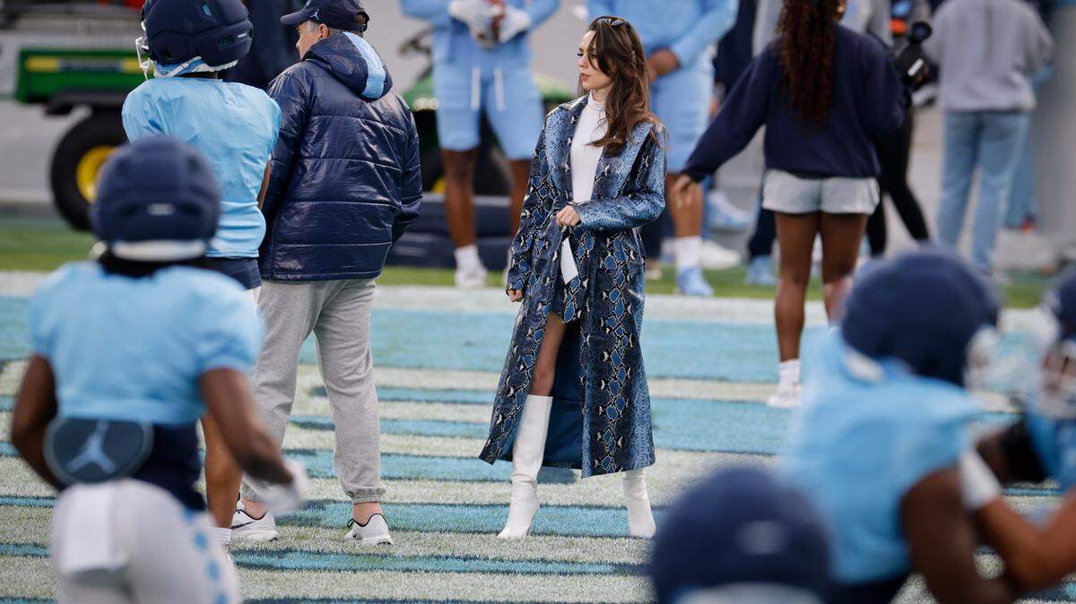 Jordon Hudson, girlfriend of UNC football coach Bill Belichick (left, in dark blue parka) on the field during UNC football’s Practice Like a Pro open practice at Kenan Stadium in Chapel Hill, N.C., Saturday, April 12, 2025.