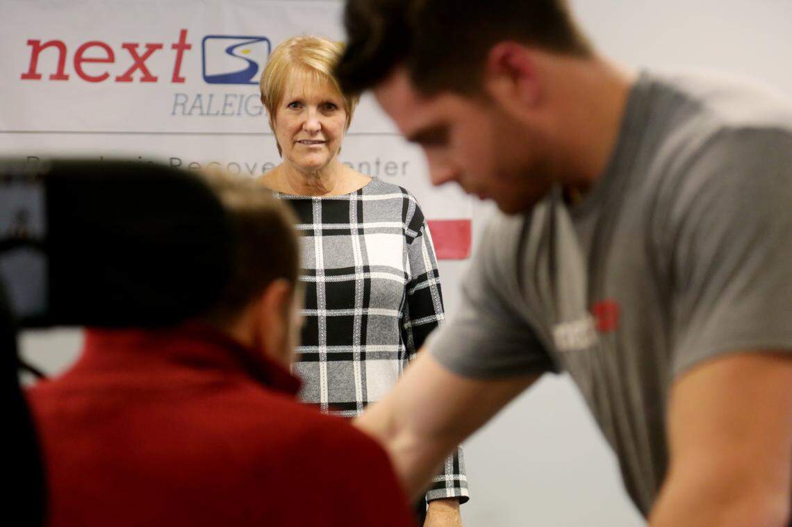 Karen Thor, center, watches as her son, Michael Thor, left, works with activity based trainer David Wright at Next Step Raleigh on Dec. 6, 2018. Karen Thor opened the local franchise of the non-profit physical therapy chain NextStep, enabling Michael to come home from Atlanta and work out multiple times per week.