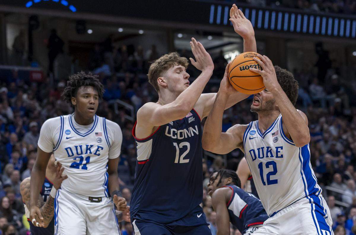 Duke forward Cameron Boozer (12) gets hit in the face by Connecticut center Eric Reibe (12) in the first half on Sunday, March 29, 2026, in the NCAA East Regional Final, at Capital One Arena in Washington, D.C. 