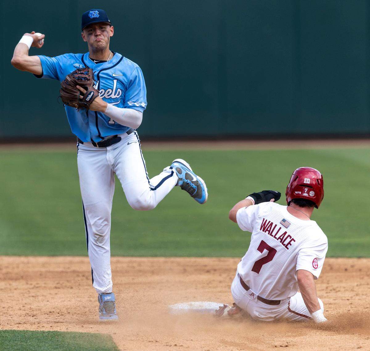 North Carolina short stop Danny Serretti (1) throws to first to turn a double play after forcing out Arkansas Cayden Wallace (7) at second base in the fifth inning during game two of their NCAA Super Regional series on Sunday, June 12, 2022 at Boshamer Stadium in Chapel Hill, N.C.