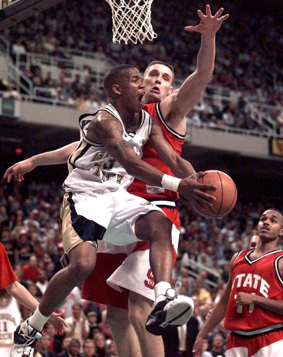 Georgia Tech’s Stephon Marbury dishes off as he drives around N.C. State’s Todd Fuller in a game in 1996.