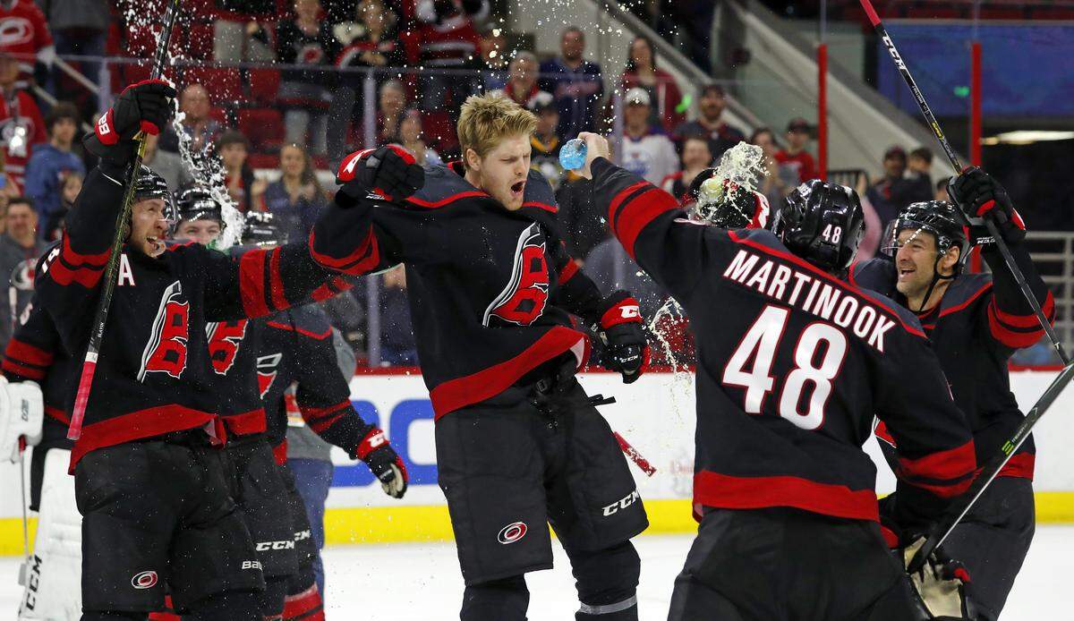 Carolina Hurricanes’ Warren Foegele (13) and teammates celebrate at center ice after a win over the Edmonton Oilers, Friday, Feb. 15, 2019, in Raleigh, N.C. (AP Photo/Karl B DeBlaker)