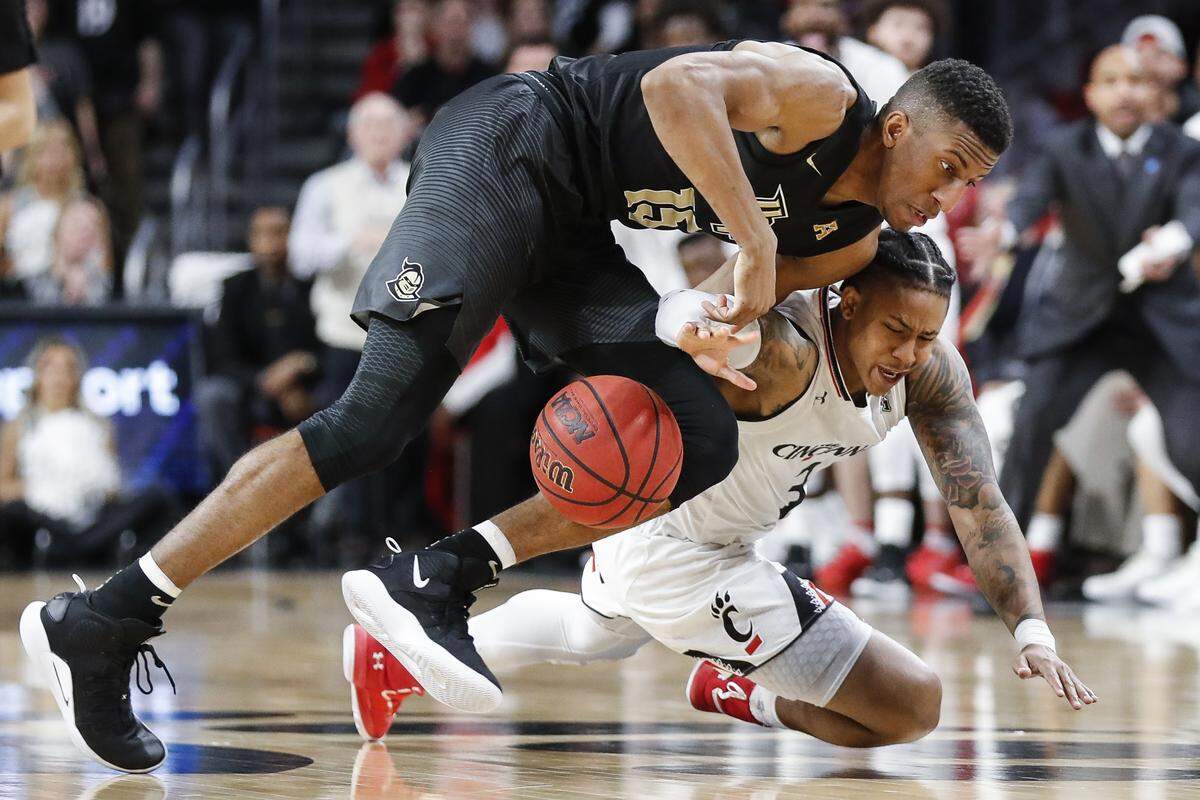 Cincinnati guard Justin Jenifer (3) and Central Florida guard Aubrey Dawkins (15) scramble for a loose ball during the first half of an NCAA college basketball game Thursday, Feb. 21, 2019, in Cincinnati.