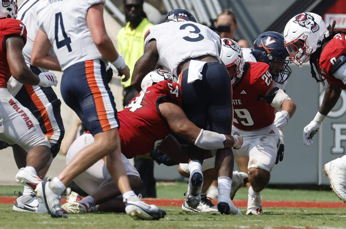 On fourth and one from the N.C. State 8-yard line N.C. State’s Sabastian Harsh (54) and Brody Barnhardt (29) stop Virginia running back J'Mari Taylor (3) for no gain, causing Virginia to turn the ball over on downs, in the fourth quarter of N.C. State’s 35-31 victory over Virginia at Carter-Finley Stadium in Raleigh, N.C., Sat. Sept. 6, 2025.