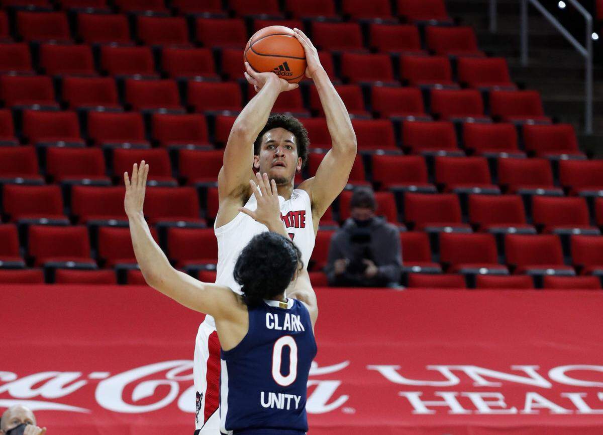 N.C. State’s Jericole Hellems (4) shoots as Virginia’s Kihei Clark (0) defends during the first half of N.C. State’s game against Virginia at PNC Arena in Raleigh, N.C., Wednesday, February 3, 2021.