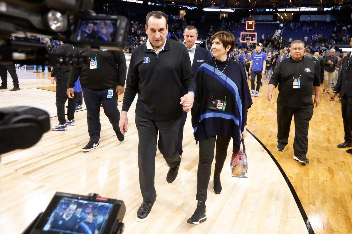 Duke head coach Mike Krzyzewski and his wife, Mickie, walk off the court after Duke’s 78-69 victory over Arkansas in the NCAA Tournament West Regional finals at the Chase Center in San Francisco, Calif., Saturday, March 26, 2022.