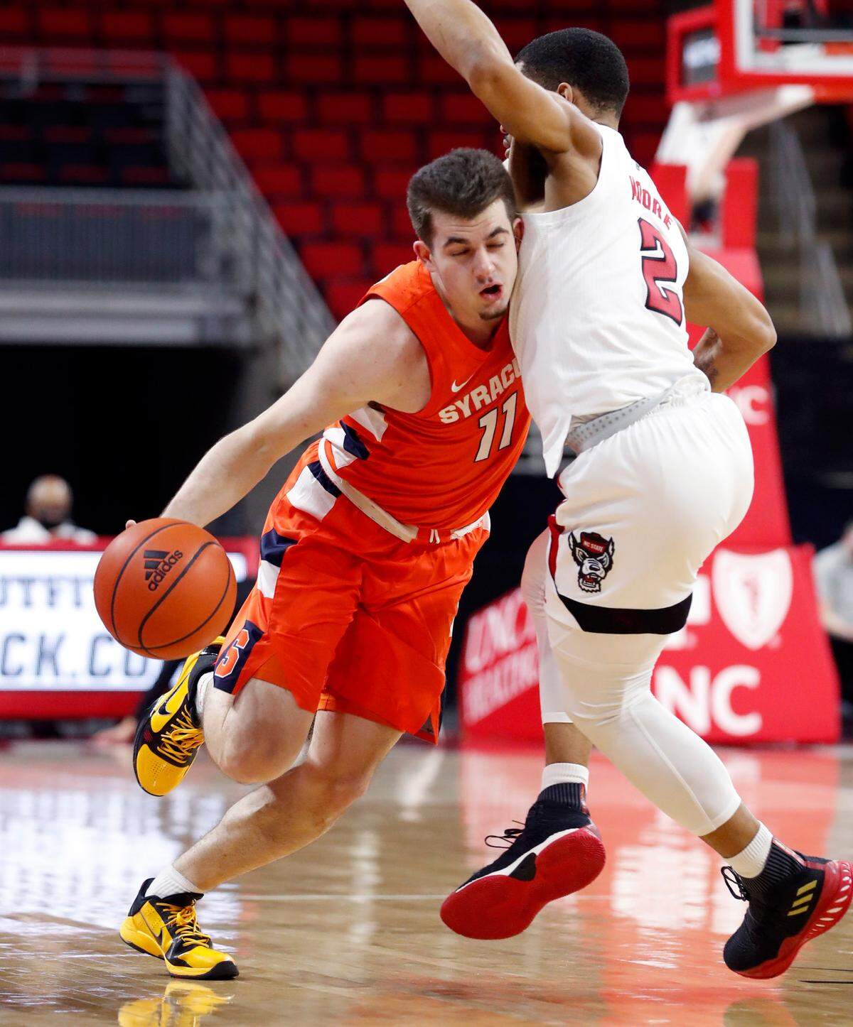 Syracuse’s Joseph Girard III (11) drives around N.C. State’s Shakeel Moore (2) during the first half of N.C. State’s game against Syracuse at PNC Arena in Raleigh, N.C., Tuesday, February 9, 2021.