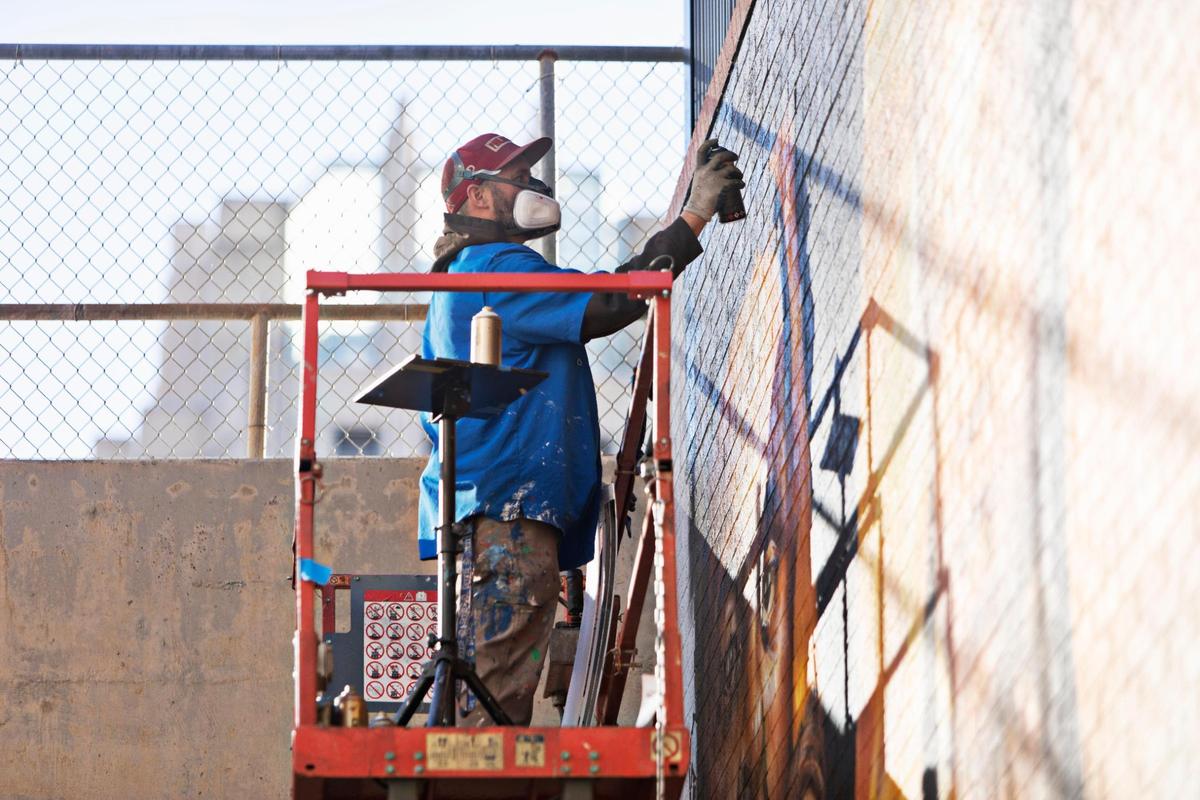 Artist Sean Kernick works on the finishing touches of his mural to honor NCCU coach LaVelle Moton on Salibury St. in downtown Raleigh on Tuesday, Nov. 23. 2021.