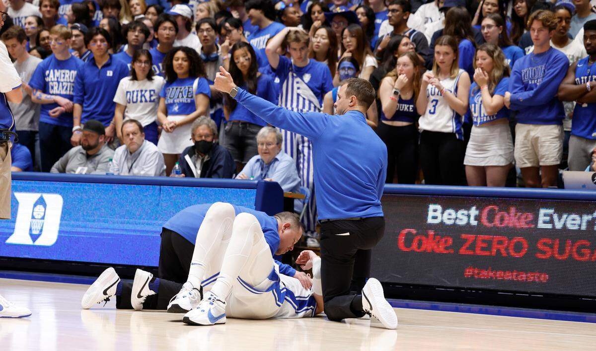 Duke trainer Jose Fonseca and head coach Jon Scheyer look at Kyle Filipowski after he was injured during the first half of Duke’s game against Bucknell at Cameron Indoor Stadium in Durham, N.C., Friday, Nov. 17, 2023.